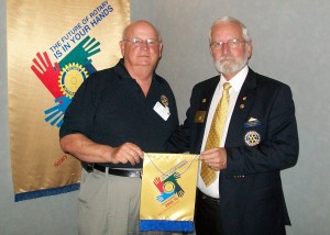 Rotary Club of Bathurst President Bob Comeau is presented with a banner from District 7810 Governor Gordon Dempsey